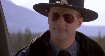 Movie still from “I'll Be Home for Christmas” (1998), directed by Arlene Sanford – A man in a hat and sunglasses is wearing a uniform; Close Up shot, Low angle