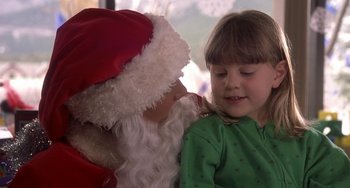 Movie still from “I'll Be Home for Christmas” (1998), directed by Arlene Sanford – A little girl sitting next to a santa clause; Close Up shot, High angle