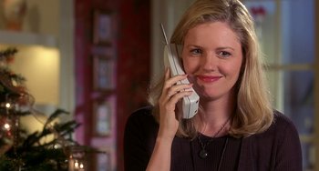 Movie still from “I'll Be Home for Christmas” (1998), directed by Arlene Sanford – A woman is holding a cell phone up to her ear; Close Up shot, Low angle