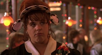 Movie still from “I'll Be Home for Christmas” (1998), directed by Arlene Sanford – A woman wearing a hat with a cow print on top of her head; Close Up shot, Over the shoulder angle