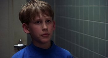 Movie still from “I'll Be Home for Christmas” (1998), directed by Arlene Sanford – A boy in a blue shirt is looking at the camera; Close Up shot, Low angle