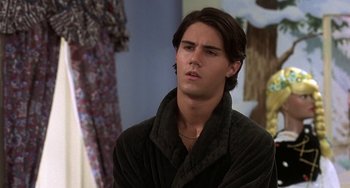 Movie still from “I'll Be Home for Christmas” (1998), directed by Arlene Sanford – A young man in a black robe looks at the camera; Close Up shot, High angle
