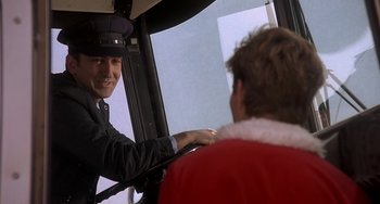 Movie still from “I'll Be Home for Christmas” (1998), directed by Arlene Sanford – A man wearing a hat is sitting on a bus; Close Up shot, Over the shoulder angle