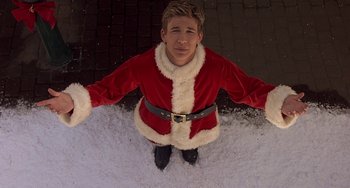 Movie still from “I'll Be Home for Christmas” (1998), directed by Arlene Sanford – A man in a santa suit sitting in the snow; Medium shot, High angle