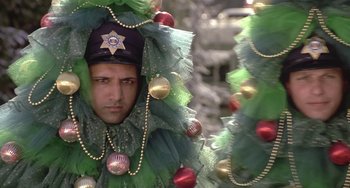 Movie still from “I'll Be Home for Christmas” (1998), directed by Arlene Sanford – A man in a christmas tree costume with beads; Close Up shot, Low angle
