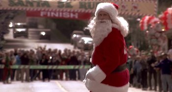Movie still from “I'll Be Home for Christmas” (1998), directed by Arlene Sanford – A man dressed as santa claus in front of a crowd of onlookers; Medium shot, Low angle