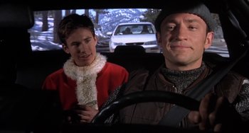 Movie still from “I'll Be Home for Christmas” (1998), directed by Arlene Sanford – A man and a woman in the driver's seat of a car; Close Up shot, Over the shoulder angle