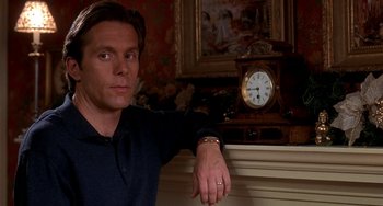 Movie still from “I'll Be Home for Christmas” (1998), directed by Arlene Sanford – A person leaning against a wall near a clock; Close Up shot, Over the shoulder angle