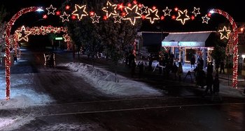 Movie still from “I'll Be Home for Christmas” (1998), directed by Arlene Sanford – A street scene at night with a lot of lights; Extreme Wide shot, High angle