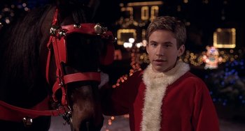 Movie still from “I'll Be Home for Christmas” (1998), directed by Arlene Sanford – A man in a santa clause outfit standing next to a horse; Close Up shot, High angle