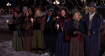 Movie still from “I'll Be Home for Christmas” (1998), directed by Arlene Sanford – A group of women dressed in period clothing holding candles; Medium shot, High angle
