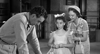 Movie still from “I'll Cry Tomorrow” (1955), directed by Daniel Mann – An old black and white photo of a man and a woman and a little girl; Medium shot, Over the shoulder angle