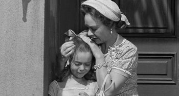 Movie still from “I'll Cry Tomorrow” (1955), directed by Daniel Mann – An older woman and a young girl are combing each other's hair; Medium shot, Over the shoulder angle