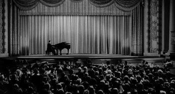 Movie still from “I'll Cry Tomorrow” (1955), directed by Daniel Mann – A man playing a grand piano in front of an audience; Extreme Wide shot, High angle