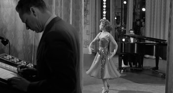 Movie still from “I'll Cry Tomorrow” (1955), directed by Daniel Mann – A woman in a dress is dancing in front of a man; Wide shot, Low angle