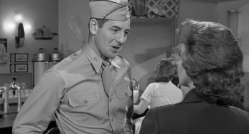 Movie still from “I'll Cry Tomorrow” (1955), directed by Daniel Mann – A man in a military uniform talking to a woman; Medium shot, Over the shoulder angle