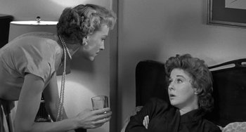 Movie still from “I'll Cry Tomorrow” (1955), directed by Daniel Mann – A woman talking to another woman holding a glass; Medium shot, Over the shoulder angle