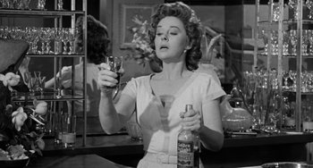Movie still from “I'll Cry Tomorrow” (1955), directed by Daniel Mann – A woman holding a wine glass in a room; Medium shot, Low angle