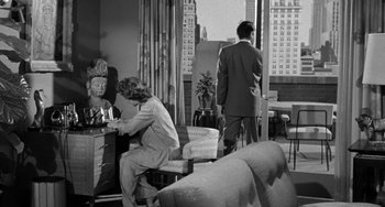 Movie still from “I'll Cry Tomorrow” (1955), directed by Daniel Mann – A man and a woman are sitting at a table in front of a window; Wide shot, High angle