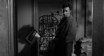Movie still from “I'll Cry Tomorrow” (1955), directed by Daniel Mann – A black and white photo of a man in a trench coat; Medium shot, Low angle