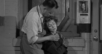 Movie still from “I'll Cry Tomorrow” (1955), directed by Daniel Mann – A man and a woman embracing in an industrial setting; Medium shot, Low angle