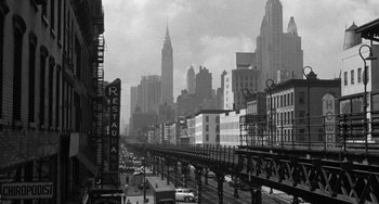 Movie still from “I'll Cry Tomorrow” (1955), directed by Daniel Mann – A black - and - white photo of a city street; Extreme Wide shot, Low angle