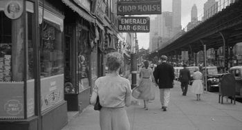 Movie still from “I'll Cry Tomorrow” (1955), directed by Daniel Mann – A black and white photo of people walking down the sidewalk; Wide shot, Over the shoulder angle