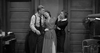 Movie still from “I'll Cry Tomorrow” (1955), directed by Daniel Mann – A man and two women standing next to each other in front of a door; Medium shot, High angle