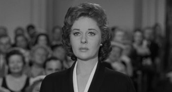 Movie still from “I'll Cry Tomorrow” (1955), directed by Daniel Mann – A black - and - white photo of a woman in front of a group of people; Close Up shot, Over the shoulder angle