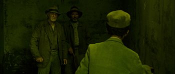 Movie still from “I'm Not There” (2007), directed by Todd Haynes – Two men standing next to each other in front of a wall; Medium shot, High angle