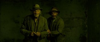 Movie still from “I'm Not There” (2007), directed by Todd Haynes – Two older men standing next to each other; Medium shot, Low angle