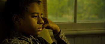 Movie still from “I'm Not There” (2007), directed by Todd Haynes – A young man sitting in front of a window with his hand under his chin; Close Up shot, High angle