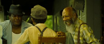 Movie still from “I'm Not There” (2007), directed by Todd Haynes – A man sitting next to another man in a chair; Medium shot, Over the shoulder angle