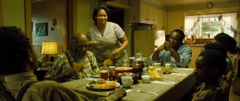 Movie still from “I'm Not There” (2007), directed by Todd Haynes – A group of people sitting at a table with plates of food; Medium shot, High angle