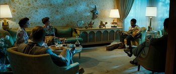 Movie still from “I'm Not There” (2007), directed by Todd Haynes – A living room filled with furniture next to a lamp; Wide shot, High angle