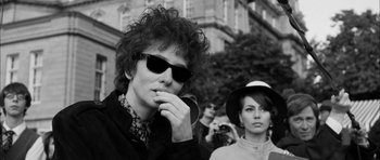Movie still from “I'm Not There” (2007), directed by Todd Haynes – A young man and a young woman wearing sunglasses; Close Up shot, Over the shoulder angle