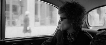 Movie still from “I'm Not There” (2007), directed by Todd Haynes – A woman sitting in the passenger seat of a car looking out the window; Close Up shot, Over the shoulder angle