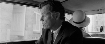 Movie still from “I'm Not There” (2007), directed by Todd Haynes – Black and white photograph of a man sitting in a car; Close Up shot, Over the shoulder angle