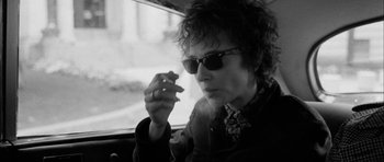 Movie still from “I'm Not There” (2007), directed by Todd Haynes – A man smoking a cigarette while sitting in a car; Medium shot, Low angle