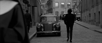 Movie still from “I'm Not There” (2007), directed by Todd Haynes – An old car parked on the side of the street; Wide shot, Over the shoulder angle