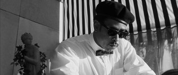 Movie still from “I'm Not There” (2007), directed by Todd Haynes – A black and white photo of a man wearing a bow tie; Close Up shot, Low angle