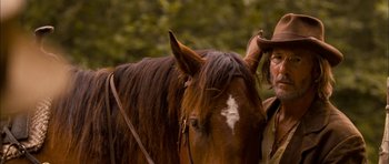 Movie still from “I'm Not There” (2007), directed by Todd Haynes – A man standing next to a brown horse; Close Up shot, Over the shoulder angle