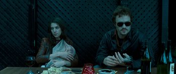 Movie still from “I'm Not There” (2007), directed by Todd Haynes – A man and a woman sitting at a dinner table; Medium shot, High angle