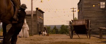 Movie still from “I'm Not There” (2007), directed by Todd Haynes – A horse drawn carriage in the middle of a dirt field; Wide shot, Over the shoulder angle