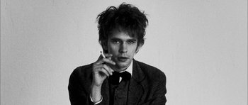 Movie still from “I'm Not There” (2007), directed by Todd Haynes – Black and white photograph of a man smoking a cigarette; Close Up shot, Low angle