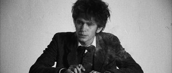 Movie still from “I'm Not There” (2007), directed by Todd Haynes – A black and white photo of a man smoking a cigarette; Close Up shot, Low angle