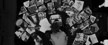 Movie still from “I'm Not There” (2007), directed by Todd Haynes – A person sitting in front of a typewriter surrounded by pictures; Wide shot, Overhead angle