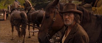 Movie still from “I'm Not There” (2007), directed by Todd Haynes – A man standing in front of a brown horse; Close Up shot, Over the shoulder angle