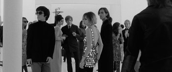 Movie still from “I'm Not There” (2007), directed by Todd Haynes – A black and white photo of a group of people; Medium shot, Over the shoulder angle