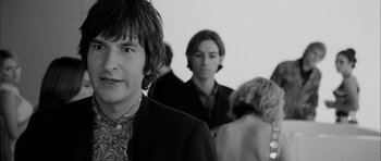 Movie still from “I'm Not There” (2007), directed by Todd Haynes – A black and white photo of a man in a suit; Close Up shot, Over the shoulder angle